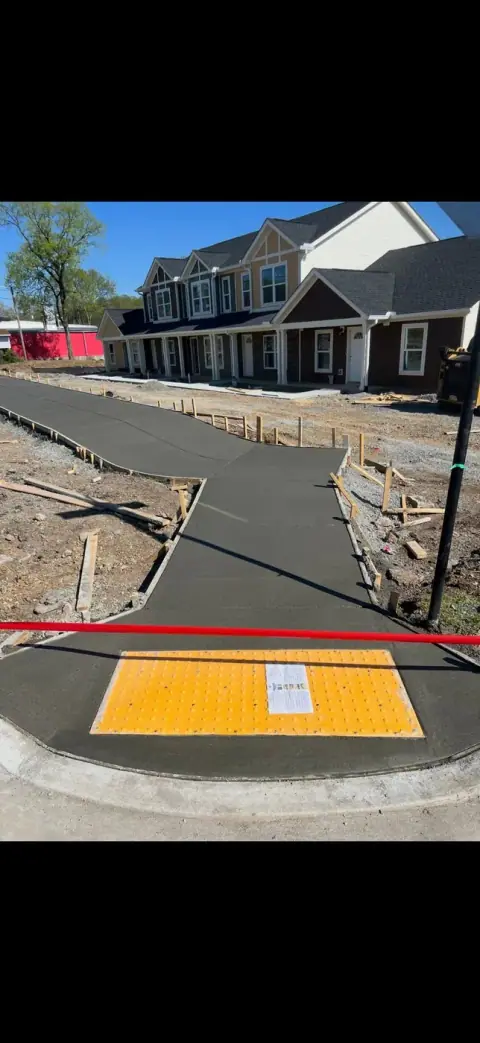 Commercial concrete sidewalk with a yellow ADA truncated dome pad