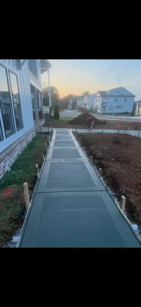 Concrete sidewalk run finished straight and true between two homes at dusk