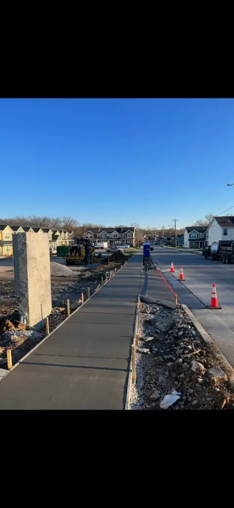 Freshly poured concrete sidewalk running through a subdivision