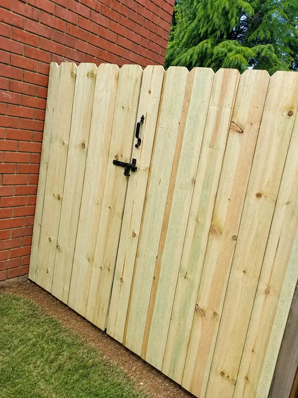 Wood privacy fence with a matching walk gate and black strap hardware