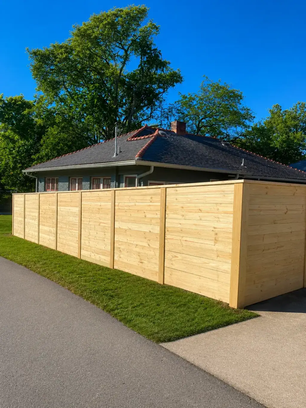 Tall horizontal board privacy fence running along a property line