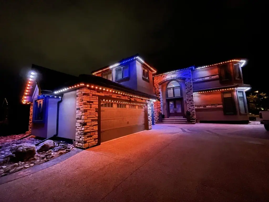 Home outlined with colorful lights at night, completed through our holiday lighting installation services
