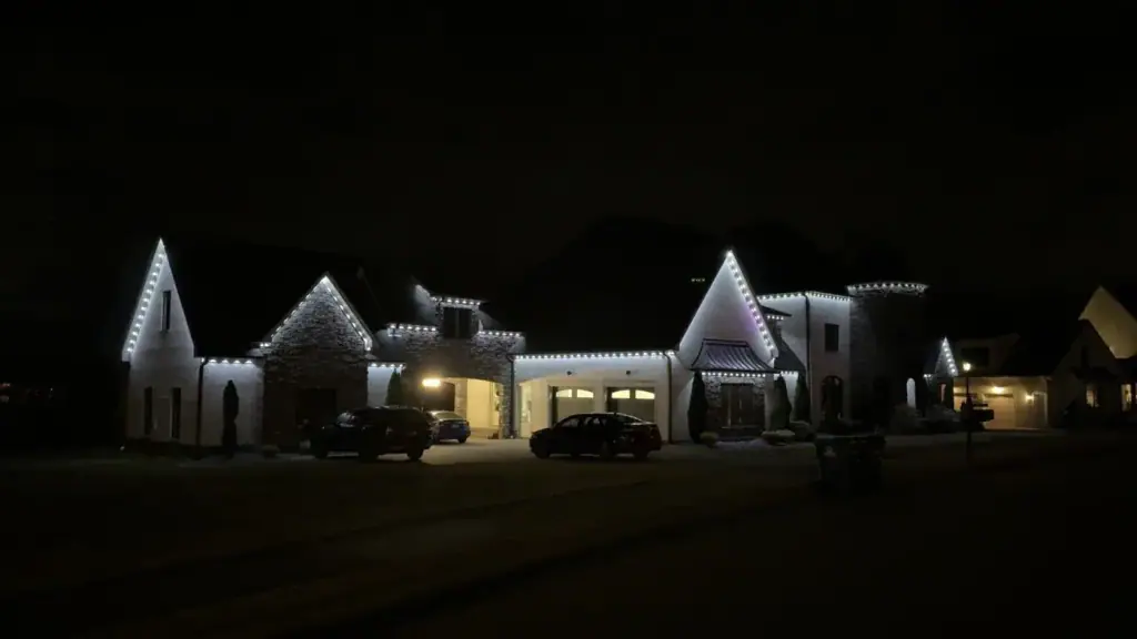 Large multi gable property lit end to end with cool white lighting at night