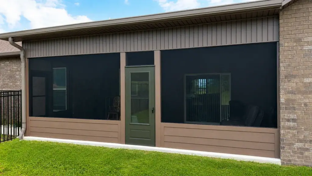 Screened room built across the back of a brick home with a full glass door